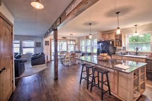 a kitchen and living room with a counter and chairs at Bright Shawano Lake Oasis - Walk to Boat Launch! in Shawano