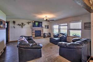 a living room with leather couches and a tv at Bright Shawano Lake Oasis - Walk to Boat Launch! in Shawano