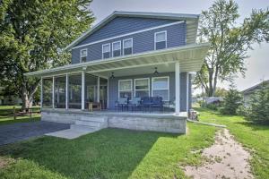 a house with a porch with blue chairs on it at Bright Shawano Lake Oasis - Walk to Boat Launch! in Shawano