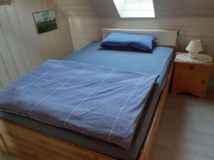 a bed in a small room with a blue comforter at Ferienwohnung am Schloss in Königstein in Kürmreuth