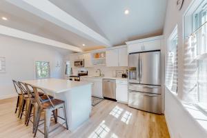 a kitchen with white cabinets and a table and chairs at Gateway to Cape Cod in West Yarmouth