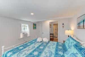 a bedroom with a bed with a blue bedspread at Gateway to Cape Cod in West Yarmouth