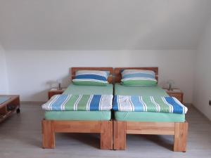 2 camas individuales en una habitación con 2 almohadas en Ferienwohnung am Schloss mit Fitnessraum en Kürmreuth