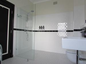 a bathroom with a shower and a toilet and a sink at The Commercial Boutique Hotel in Tenterfield +24 photos