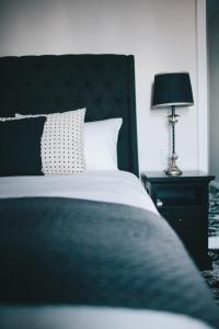 a bed with a white comforter on top of it at The Commercial Boutique Hotel in Tenterfield