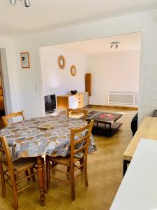 comedor y sala de estar con mesa y sillas en Appartement quartier calme en Mende