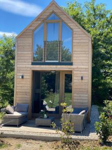 una casa con ventanas de cristal y sofás en un patio en GORIČKE IŽE en Križevci