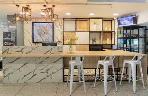 a kitchen with a large wooden counter and stools at Bianco Hotel Boutique in Cúcuta