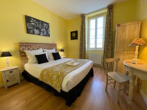 a bedroom with a bed and a desk and a window at Hôtel Le Peu Breton in Sainte-Marie-de-Ré