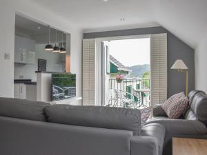 a living room with a couch and a large window at The Penthouse in Bowness-on-Windermere