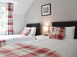 a bedroom with two beds and a lamp on a table at The Penthouse in Bowness-on-Windermere