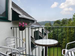 a patio with a table and chairs on a balcony at The Penthouse in Bowness-on-Windermere