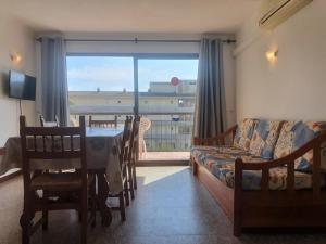 a living room with a table and a couch and a window at Payet Apartments in L'Estartit