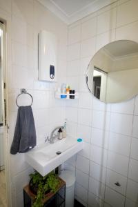 a bathroom with a sink and a mirror at Tamboerskloof 2 bed apartment in Cape Town