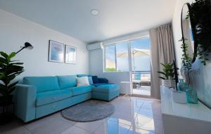 a blue couch in a living room with a view of the ocean at Mar Azul Fuerteventura in Morro del Jable