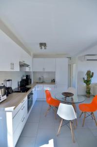 濱海自由城的住宿－Beau 2P, très équipé, localisation parfaite/AC，白色的厨房配有橙色椅子和桌子