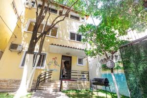 a yellow house with a fence in front of it at Relax Hostel in Tirana