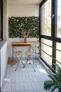 una mesa y sillas en un balcón con una planta en Apartman "Stay In" Osijek en Osijek