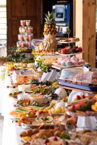 una línea de buffet con muchos tipos diferentes de comida en Tropic Hôtel, en Rivesaltes