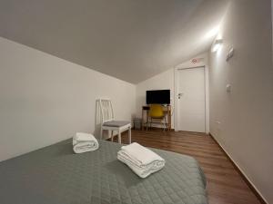 - une chambre avec un lit et 2 serviettes dans l'établissement Guest House All'83, à Grosseto