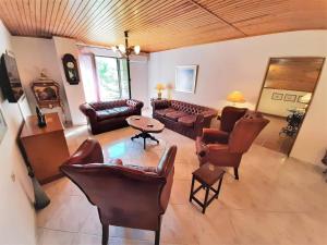 een woonkamer met banken en stoelen en een tafel bij ARCHONTISSA Lagonisi villa in Kalívia Thorikoú
