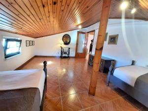 een slaapkamer met 2 bedden en een houten plafond bij ARCHONTISSA Lagonisi villa in Kalívia Thorikoú