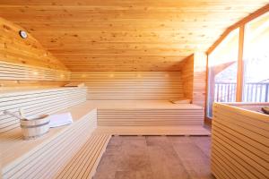 a sauna with wooden paneling and a large window at HELDs Vitalhotel in Ruhpolding