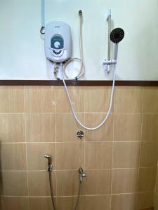 a shower with a hose attached to a wall at Pavalintang Resort in Semporna