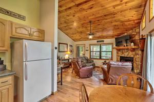een keuken en een woonkamer met een witte koelkast bij Cozy Murphy Cabin Retreat with Deck and Fire Pit! in Salem