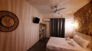 Mamma Mia apartments skiathos في مدينة سكياثوس: غرفة نوم بسرير ومروحة سقف