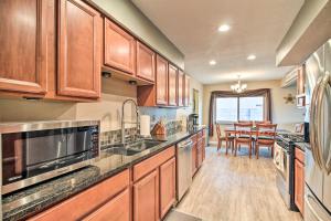 a kitchen with wooden cabinets and a dining room at Updated Albuquerque Home with Backyard and Grill! in Albuquerque