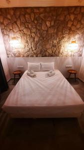Mamma Mia apartments skiathos في مدينة سكياثوس: سرير ابيض كبير عليه منشفتين