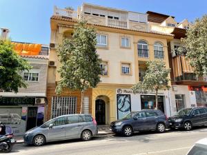 un groupe de voitures garées devant un bâtiment dans l'établissement Moderno piso de 3 dormitorios en la playa de Rincon de la Victoria Malaga, à Rincón de la Victoria