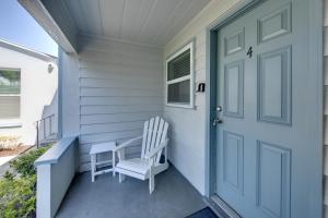 a porch with a blue door and two white chairs at Silver Sands in St Pete Beach