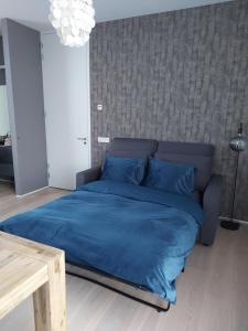 ein großes Bett mit blauer Bettwäsche in einem Schlafzimmer in der Unterkunft Bed & Wellness Boxtel, luxe kamer met airco en eigen badkamer in Boxtel