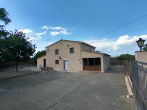 un grand bâtiment blanc avec un portail et une clôture dans l'établissement Turisme Rural Les Moreres, à Vilobí d'Onyar