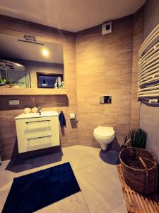 a bathroom with a white sink and a toilet at Apartament Kurort Kozubnik Wilcza Wataha in Porąbka +27 photos