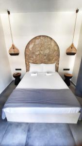 Mamma Mia apartments skiathos في مدينة سكياثوس: غرفة نوم بسرير ابيض كبير ومصباحين