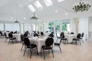 a banquet hall with tables and chairs and chandeliers at Landhotel Classhof in Willich