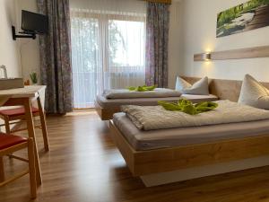Traitsching的住宿－Zur Linde，一张沙发和一张桌子的客房内的两张床