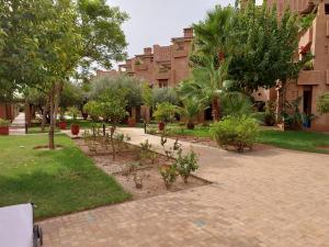 un parque con árboles y plantas en una acera en Appartement Marrakchia au jardin d'habgour, en Marrakech