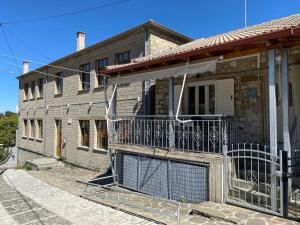 a brick house with a gate and a balcony at Sofia’s House in Pramanta
