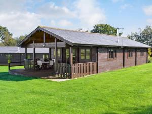 a small house with a porch and a grass field at Dalch - Uk12538 in Witheridge