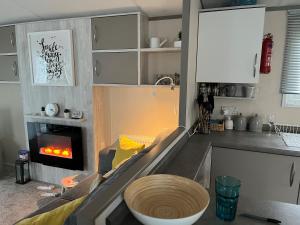 a kitchen with a living room with a fireplace at AMETHYST 25 in Whitstable