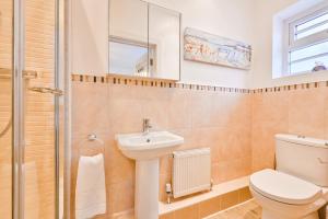 a bathroom with a toilet and a sink and a shower at No2 Ellington Court Apartment in Torquay +22 photos
