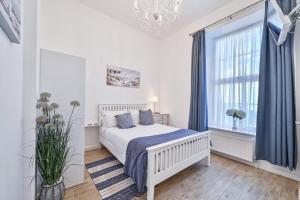 een witte slaapkamer met een bed en een raam bij No2 Ellington Court Apartment in Torquay