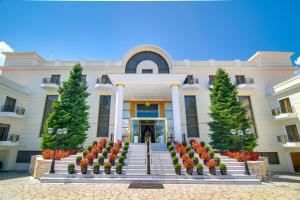 a building with a flower garden in front of it at Epirus Palace Congress & Spa in Ioannina