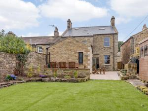 an exterior view of a stone house with a yard at Temple House in West Burton