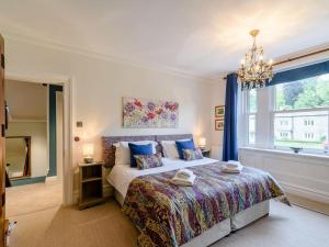 a bedroom with a large bed and a chandelier at Temple House in West Burton