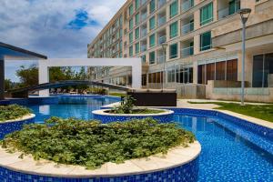 a building with two pools with plants in it at Eurobuilding Hotel & Suites Lecheria in El Morro de Barcelona